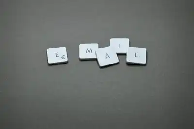 Close-up of the word 'email' formed with letter tiles on a gray surface.